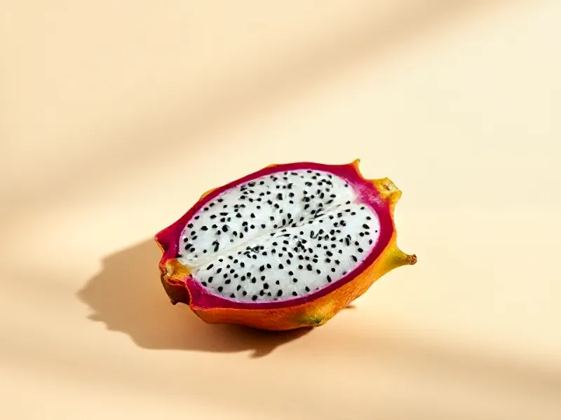 Dragon fruit cut open showing white flesh with black seeds