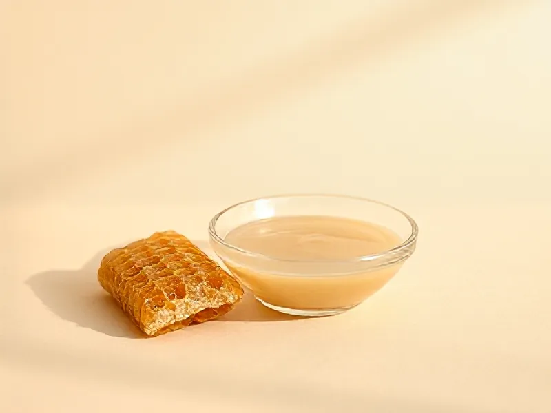 Creamy royal jelly beside a piece of honeycomb
